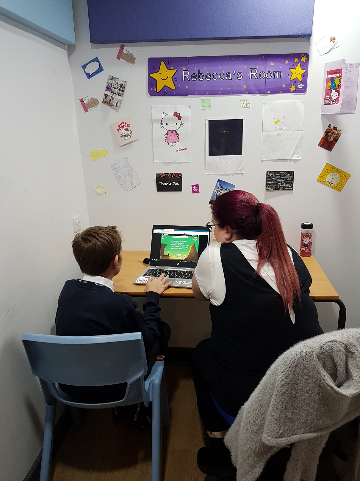 child being taught on a computer in a safe space